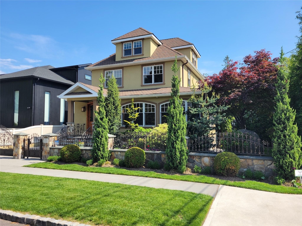 view of front of property featuring stucco siding, fence private yard, and a front yard