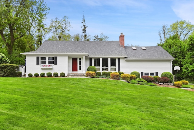 view of front facade featuring a chimney and a front yard