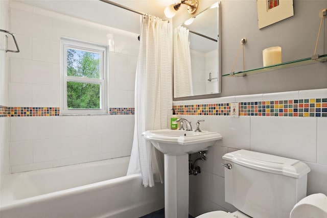 bathroom featuring toilet, shower / tub combo, and tile walls