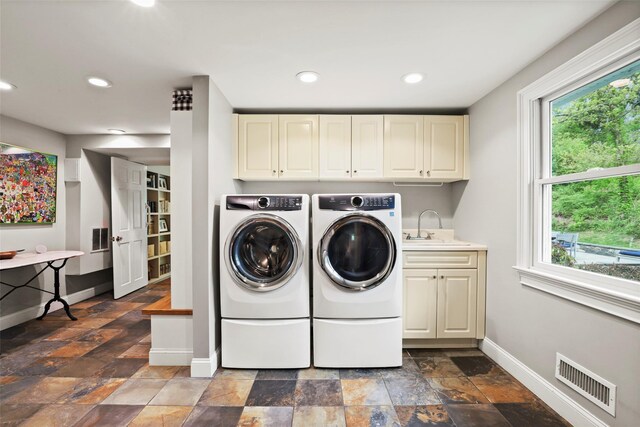 laundry room featuring washer and clothes dryer, cabinet space, baseboards, dark stone finish flooring, and recessed lighting