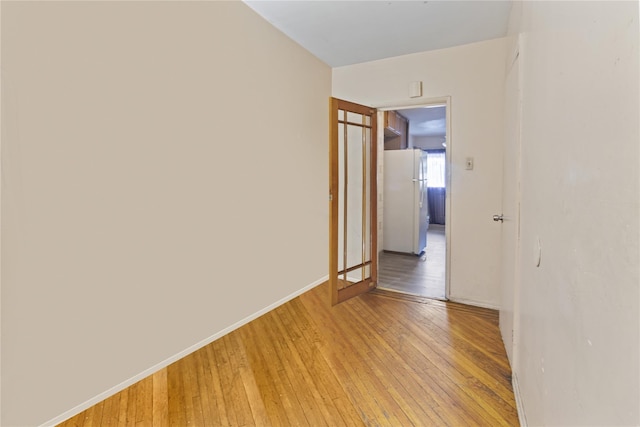 empty room featuring baseboards and light wood finished floors