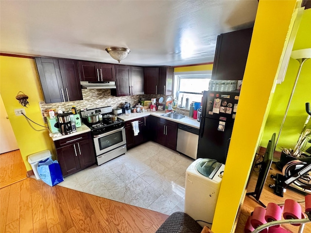 kitchen with decorative backsplash, dark brown cabinets, light countertops, under cabinet range hood, and stainless steel appliances