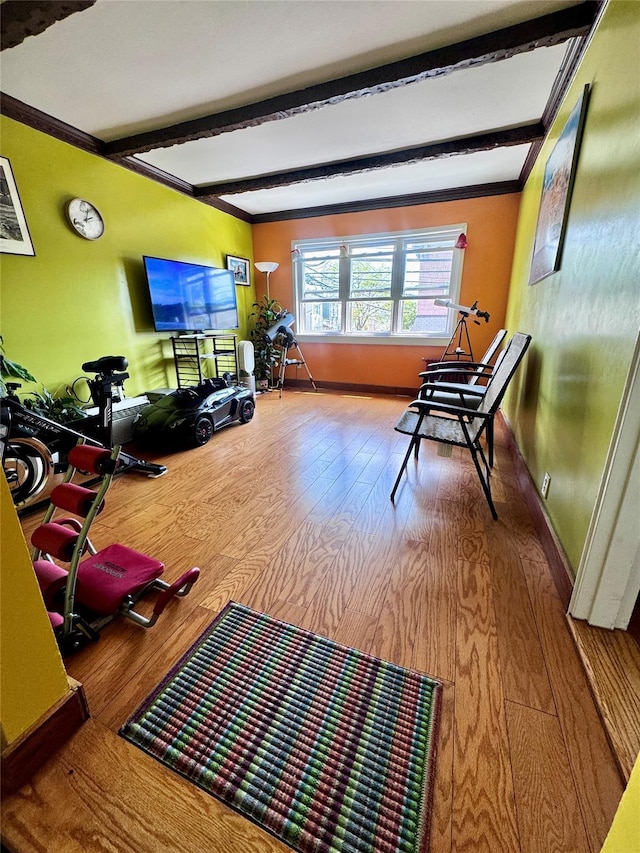 living room featuring crown molding, beamed ceiling, and wood finished floors