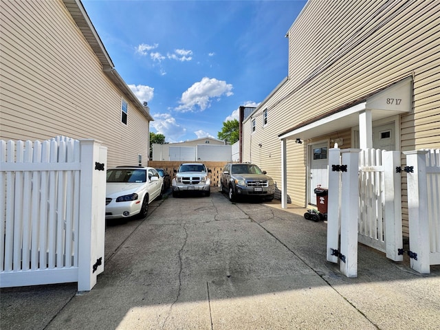 view of parking with a gate and fence