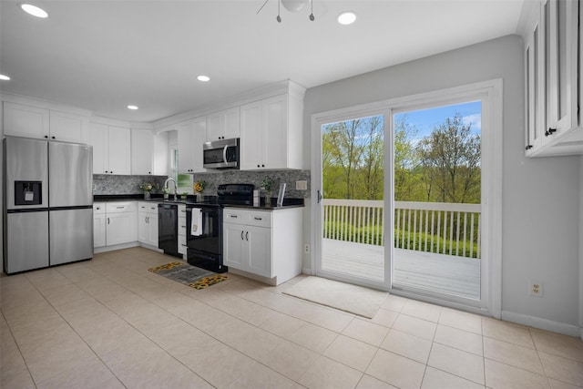 kitchen with white cabinetry, dark countertops, black appliances, and tasteful backsplash