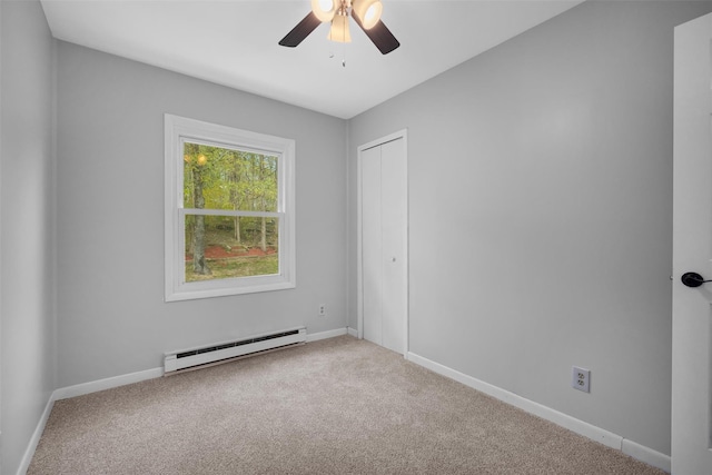 carpeted empty room featuring baseboards, ceiling fan, and a baseboard heating unit