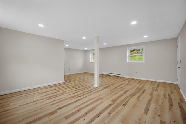 below grade area featuring recessed lighting, baseboards, baseboard heating, and light wood-type flooring