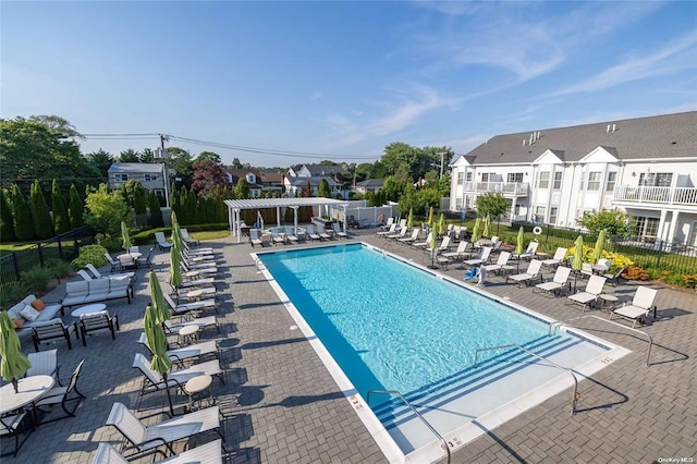 community pool with a pergola, fence, a patio, and a residential view