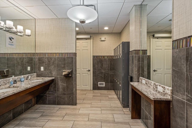 bathroom with tile walls and a sink