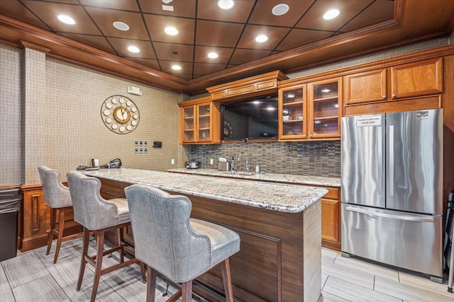 indoor wet bar featuring freestanding refrigerator, ornamental molding, tasteful backsplash, and recessed lighting
