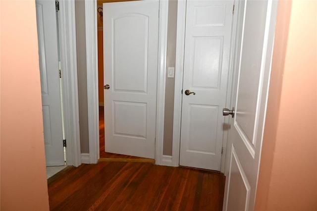 corridor featuring dark wood finished floors
