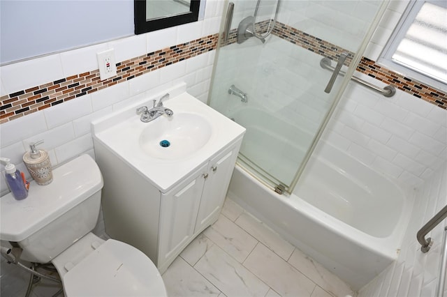 full bathroom with shower / bath combination with glass door, vanity, toilet, marble finish floor, and tile walls