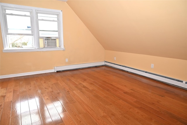 additional living space featuring baseboard heating, hardwood / wood-style flooring, baseboards, a baseboard heating unit, and lofted ceiling