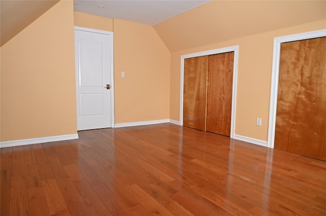 additional living space featuring baseboards, vaulted ceiling, and wood finished floors