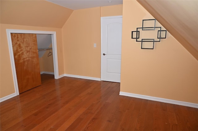 additional living space featuring baseboards, wood finished floors, and lofted ceiling