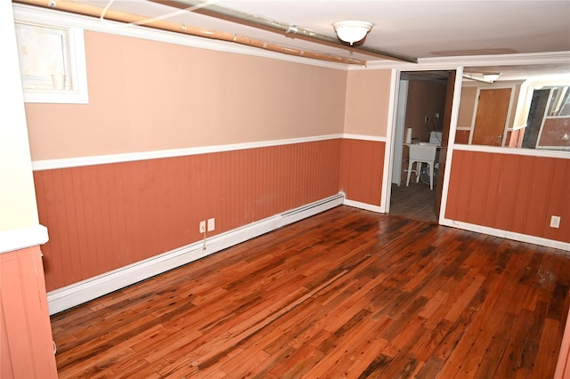 below grade area featuring wainscoting, hardwood / wood-style floors, and a baseboard radiator