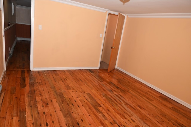 unfurnished bedroom featuring crown molding, baseboards, and hardwood / wood-style floors