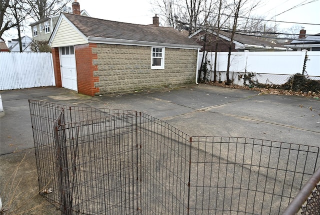 view of patio with fence, a detached garage, and an outdoor structure