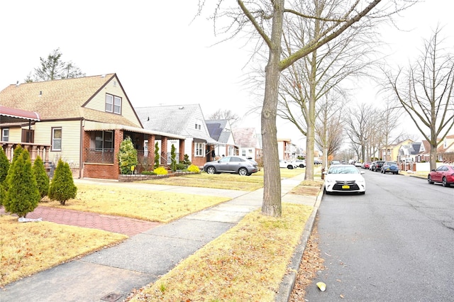 view of road with a residential view, sidewalks, and curbs