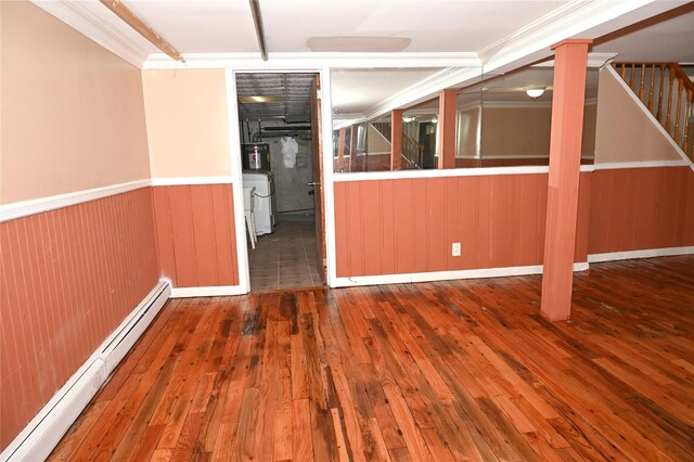 8260 266th St, Glen Oaks, NY 11004 - spare room with a baseboard heating unit, washer / dryer, hardwood / wood-style flooring, wainscoting, and stairway