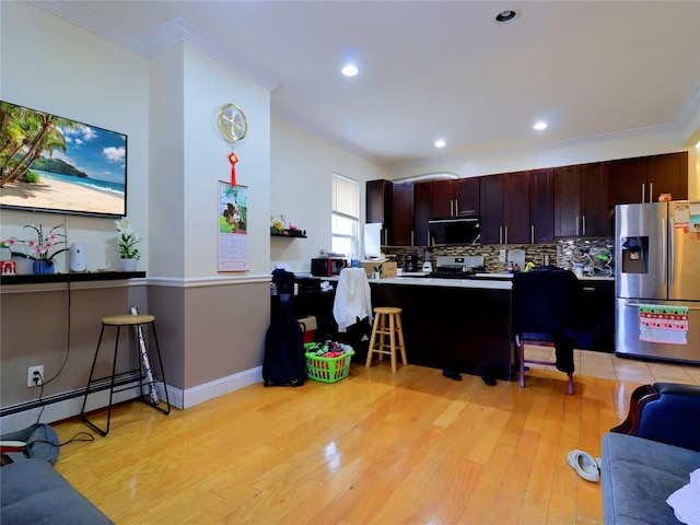 kitchen with ornamental molding, light countertops, a baseboard radiator, light wood finished floors, and stainless steel appliances