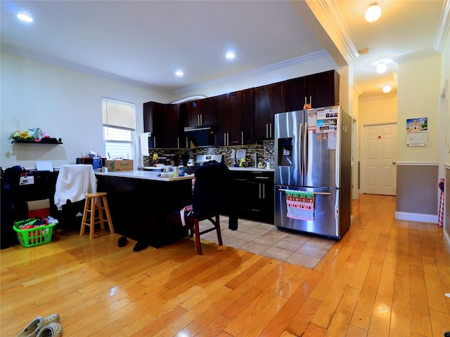 kitchen with light countertops, stainless steel fridge with ice dispenser, backsplash, and light wood-type flooring