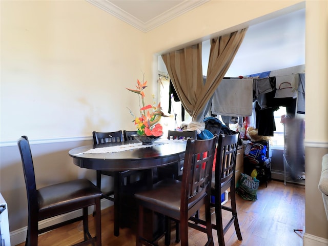 dining room with crown molding, a wealth of natural light, and wood finished floors