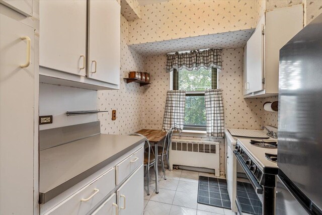 62-15 53rd Ave Unit Lgd, Maspeth, NY 11378 - kitchen with freestanding refrigerator, radiator, electric range, wallpapered walls, and light countertops