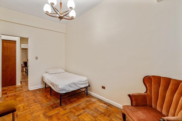 62-15 53rd Ave Unit Lgd, Maspeth, NY 11378 - bedroom featuring baseboards and a chandelier