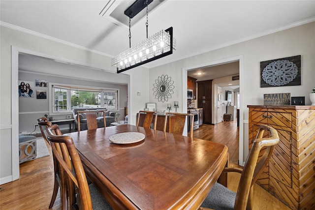 dining space with wood finished floors and ornamental molding