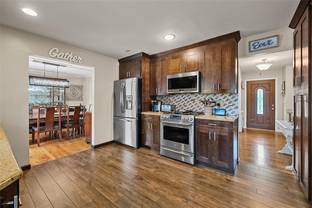 kitchen featuring appliances with stainless steel finishes, dark wood-style floors, dark brown cabinetry, and recessed lighting