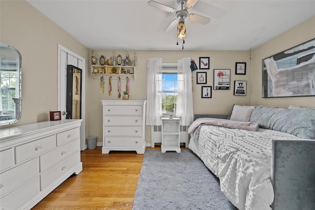 bedroom with light wood finished floors and a ceiling fan