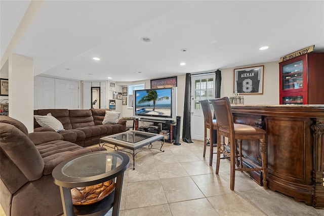 living room with light tile patterned flooring, a bar, and recessed lighting