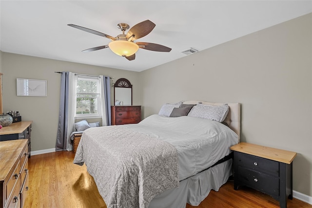 bedroom featuring light wood-type flooring, baseboards, and ceiling fan