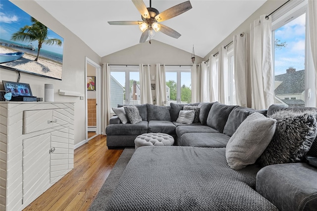 living area with lofted ceiling, wood finished floors, ceiling fan, and a baseboard radiator