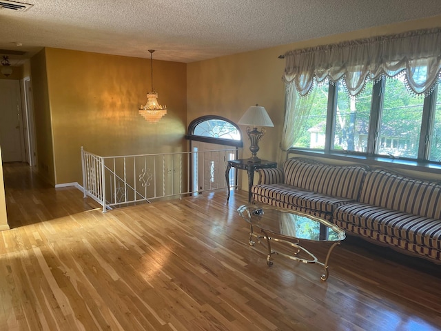 45 Princeton Dr, Tappan, NY 10983 - living room featuring wood finished floors, a textured ceiling, and a chandelier