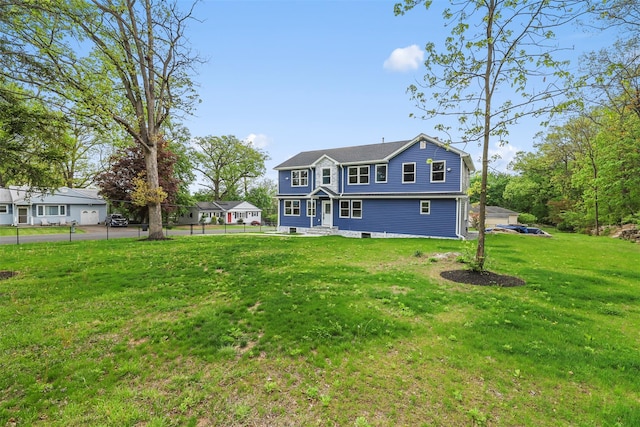 rear view of property featuring a lawn