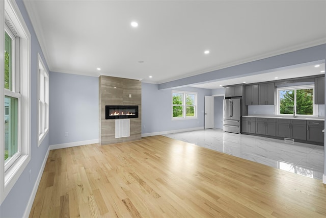 unfurnished living room featuring baseboards, recessed lighting, and crown molding