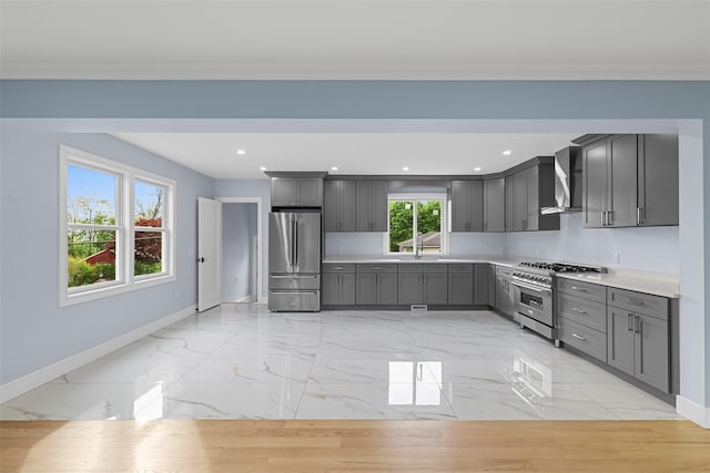 kitchen featuring gray cabinetry, marble finish floor, stainless steel appliances, and baseboards