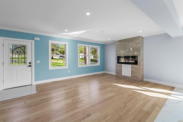 unfurnished living room with baseboards, ornamental molding, and recessed lighting