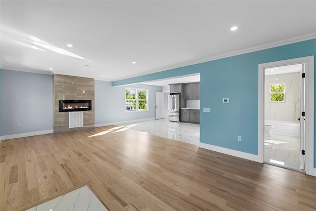 unfurnished living room featuring recessed lighting, a fireplace, crown molding, light wood-style flooring, and baseboards