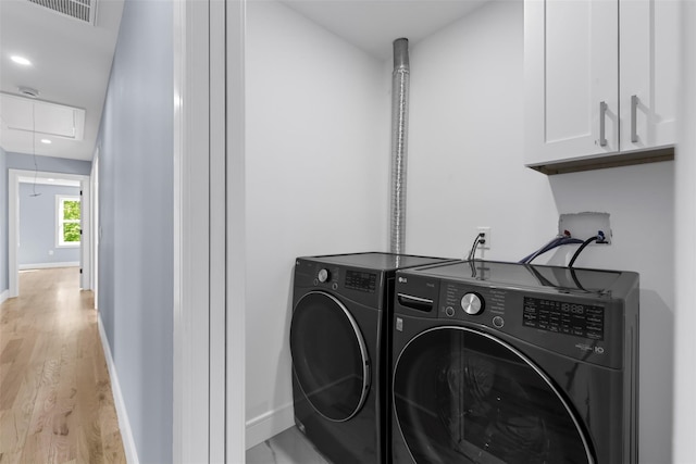 laundry room featuring cabinet space, independent washer and dryer, attic access, visible vents, and light wood finished floors