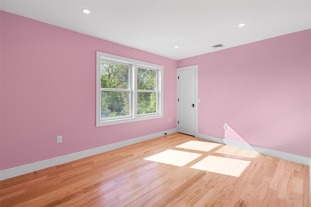 empty room with light wood-style flooring, baseboards, visible vents, and recessed lighting