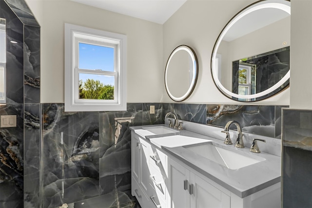 bathroom featuring double vanity, a healthy amount of sunlight, and a sink