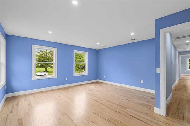 empty room with baseboards, recessed lighting, light wood finished floors, and visible vents