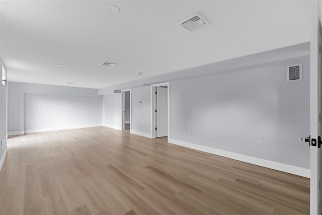 spare room with baseboards, visible vents, and light wood-style floors
