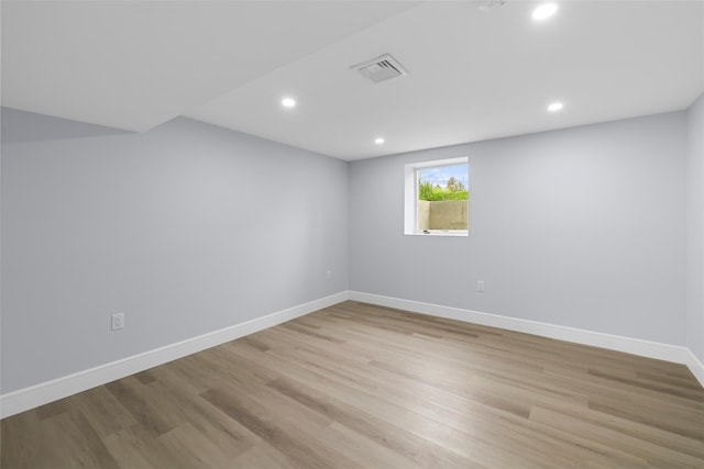 spare room with wood finished floors, visible vents, baseboards, and recessed lighting