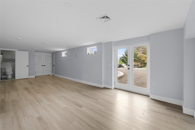 unfurnished living room with baseboards, french doors, visible vents, and light wood-style floors