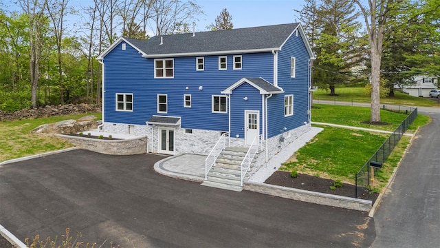 view of front of property with a patio area, french doors, a front yard, and fence