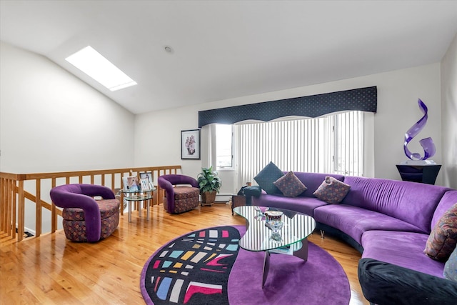 living area with a skylight, vaulted ceiling, wood finished floors, and baseboard heating